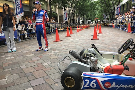 佐藤琢磨、インディ500で優勝した“本物のスーツ”で登場！丸の内でデモ走行
